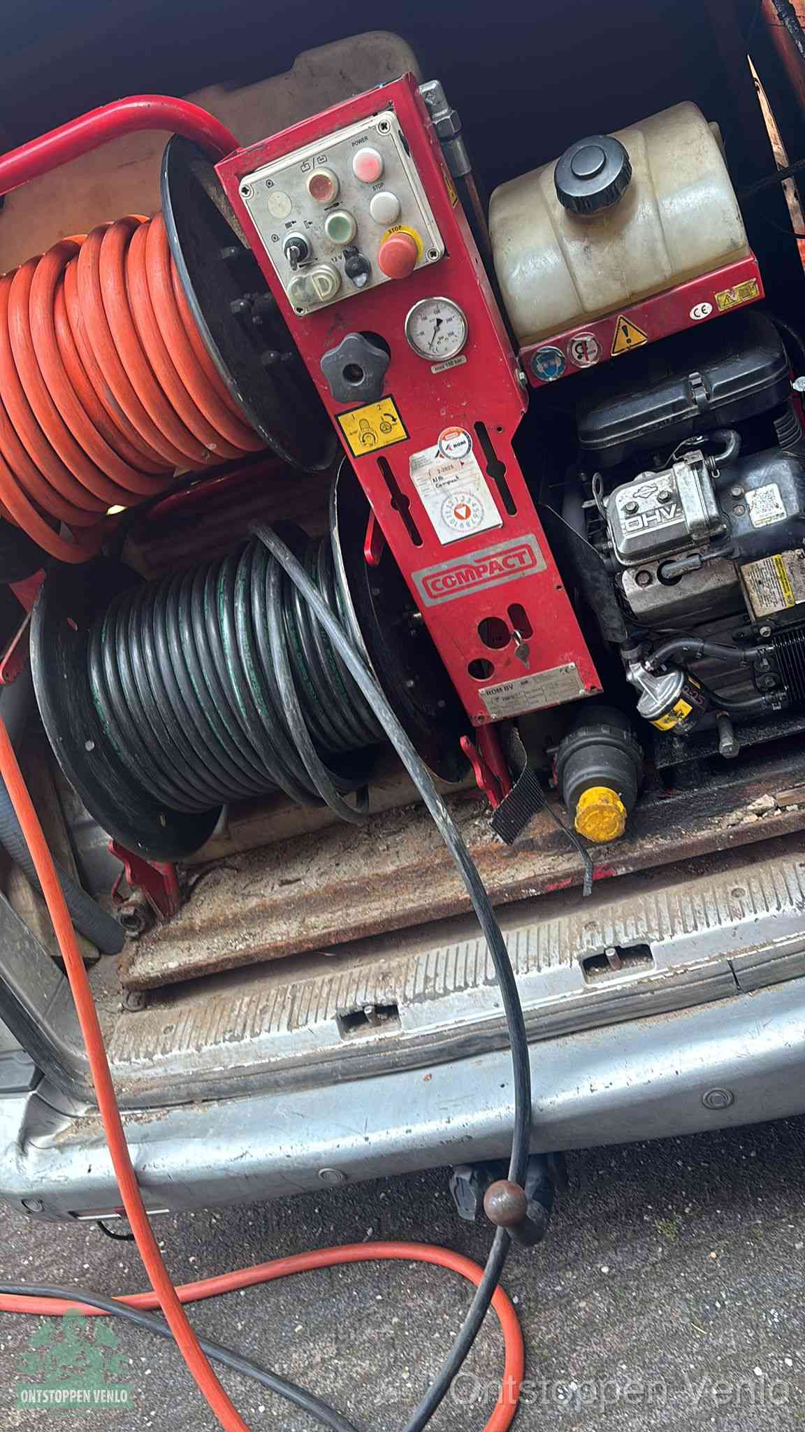 Een rood hogedruk-rioolreinigingstoestel in de laadbak van de bedrijfsbus, apparatuur voor een hardnekkige afvoerverstopping in Venlo