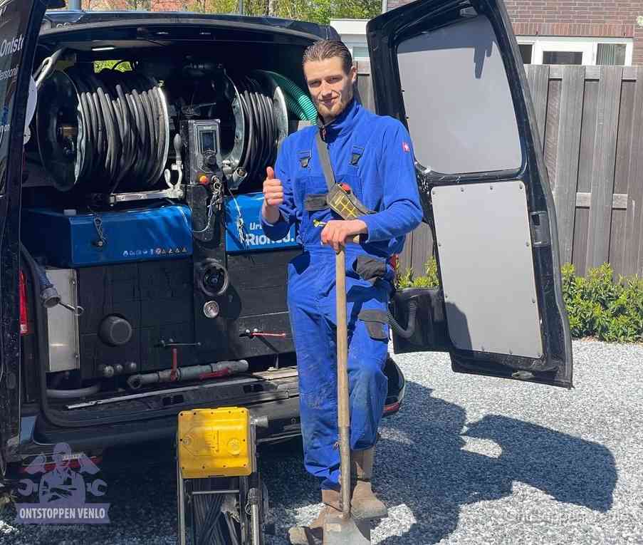 Een monteur bij de werkbus met grote hogedruk-slanghaspels, apparatuur voor hardnekkige afvoerverstoppingen in Venlo