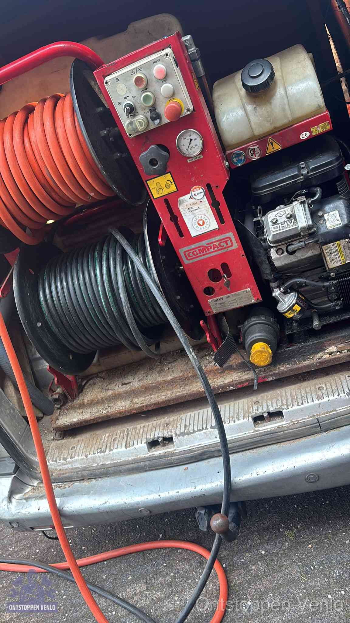 Een rood hogedruk-rioolreinigingstoestel met slangen in de laadbak van de bedrijfsbus, apparatuur voor een hardnekkige wc-verstopping in Venlo