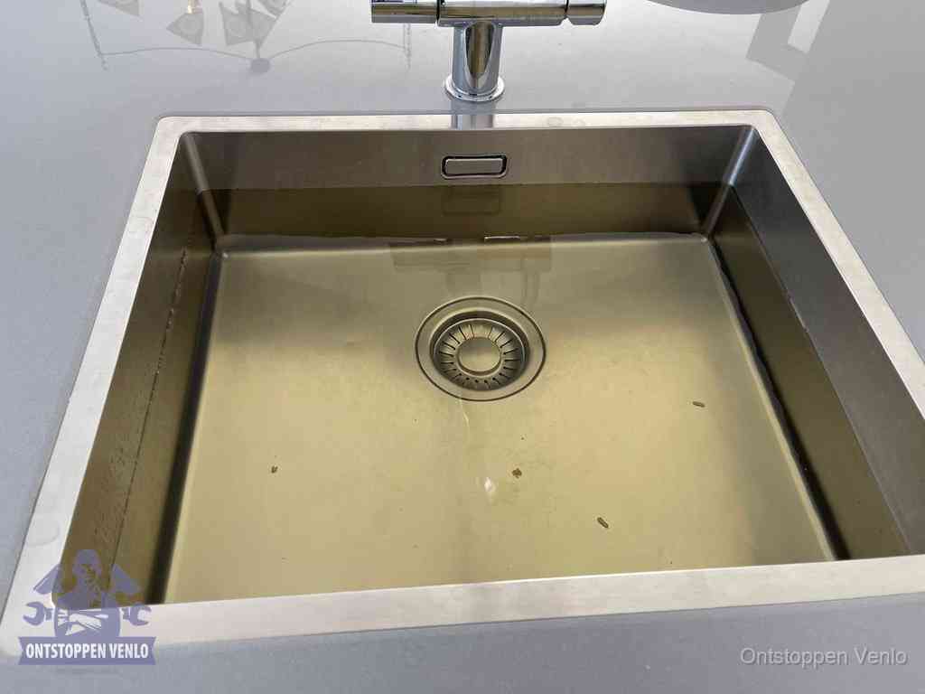 Stilstaand water in een rvs spoelbak dat niet wegloopt, een duidelijk signaal van een gootsteenverstopping in Venlo
