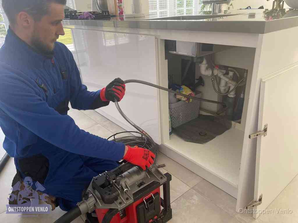 Een monteur reinigt de keukenafvoer grondig met een veermachine om terugkerende gootsteenverstoppingen te voorkomen in Venlo